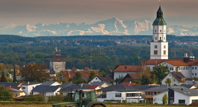 Die Stadt Langenau mit Kirchturm und den Bergen im Hintergrund.