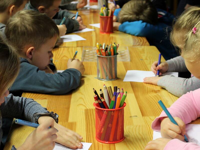 Kinder malen an einem Tisch