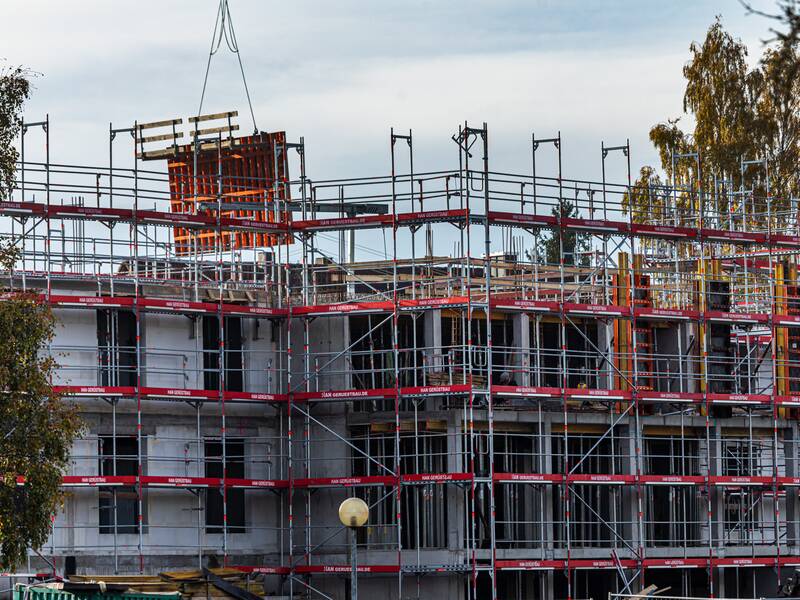 Ein Haus im Rohbau, das rundum mit einem Gerüst versehen ist.