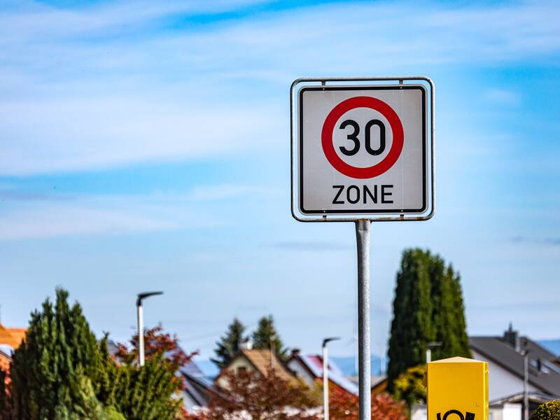 Ein Verkehrsschild, das auf den Beginn einer Tempo-30-Zone hinweist vor einem blauen Himmel.